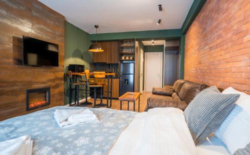 a room with a bed and a couch and a fireplace at New Gudauri Sweet Apartment With Fireplace and view The Gondola Lift in Gudauri