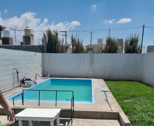 a small swimming pool with a table and a table at Alquiler temporario villa allende in Córdoba