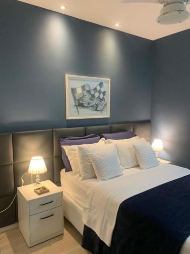 ein Schlafzimmer mit einem großen Bett und einer blauen Wand in der Unterkunft Ocean Flat Premium com vista para o mar in Vila Velha