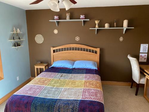 1 dormitorio con 1 cama con colcha colorida en Healing / Spiritual Oasis en Otsego