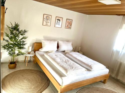 1 dormitorio con 1 cama en una habitación con planta en Ferienwohnung SeeLiebeee, en Friedrichshafen