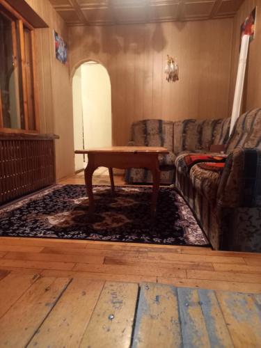 een woonkamer met een tafel en een bank bij ХОСТЕЛ FRIENDS in Karakol