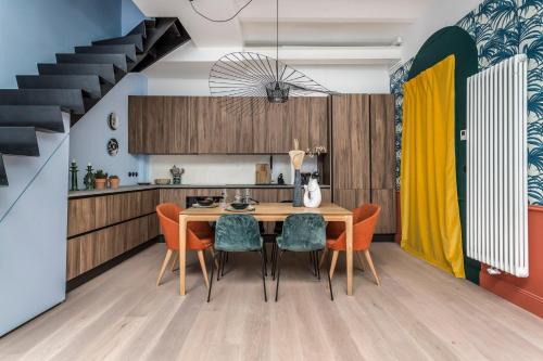 a kitchen and dining room with a wooden table and chairs at Jungle-Art - duplex très calme et cosy in Lyon