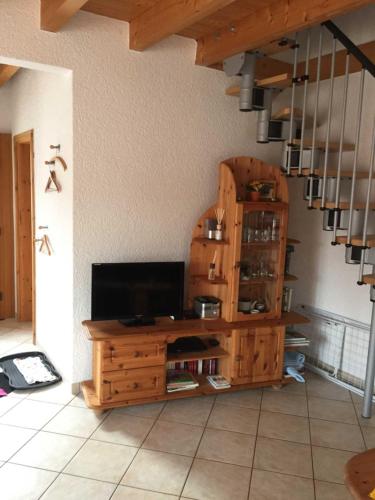 a living room with a television on a wooden cabinet at Ferienhaus Walther in Erbach