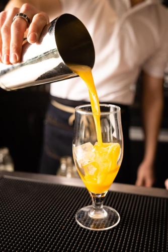 a person pouring orange juice into a glass at Campanile Limoges Centre - Gare in Limoges