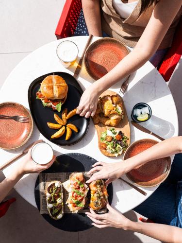 a group of people sitting around a table with food at Sholeo Lodges Los Gigantes in Puerto de Santiago