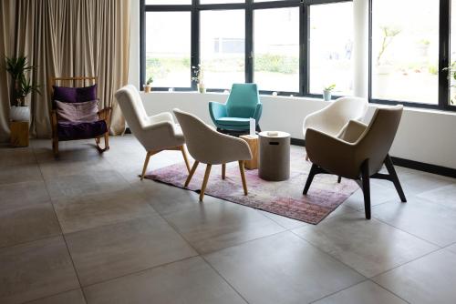 a waiting room with chairs and tables and windows at Campanile Limoges Centre - Gare in Limoges