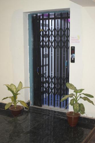 a door with a black gate with two plants at Hotel Soft Petal in Rānchī