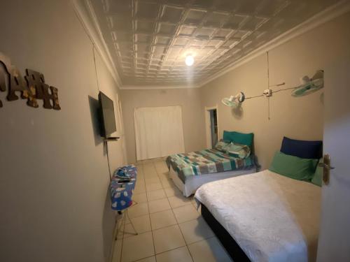 a room with two beds and a tv in it at MOMENTS OF JOY GUESTHOUSE in Boksburg
