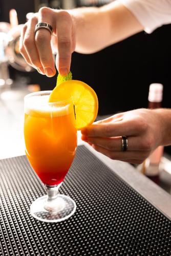 a woman is cutting an orange into a drink at Campanile Limoges Centre - Gare in Limoges
