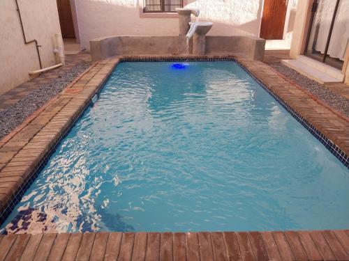 a swimming pool in a house with blue water at Pillacol Guest House in Victoria Falls