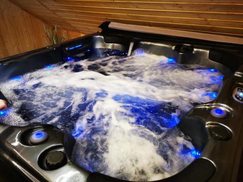a bath tub filled with water with blue lights at Apartament od Kaszuba in Żuromino