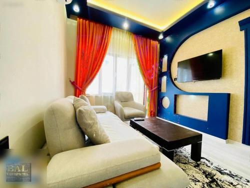 a living room with a couch and a tv at Deniz Pansiyon in Alanya