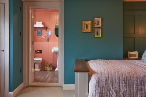a bedroom with a bed and a bathroom with a toilet at The White Horse - A Heartwood Inn in Dorking