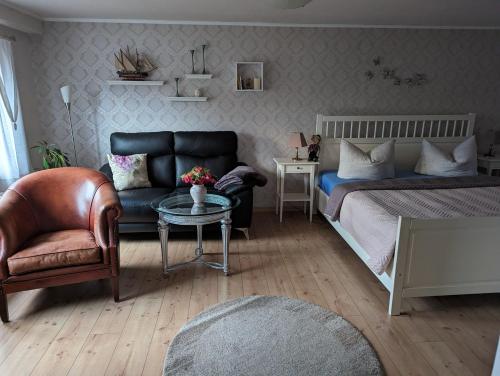 a bedroom with a bed and a couch and a table at Casa Hibiscus 2 in Putbus
