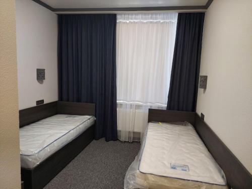 2 Betten in einem kleinen Zimmer mit Fenster in der Unterkunft Alfa in Kiliya