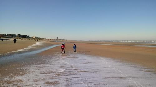 two people are walking on the beach at Appartement nabij de zee in Nieuwpoort