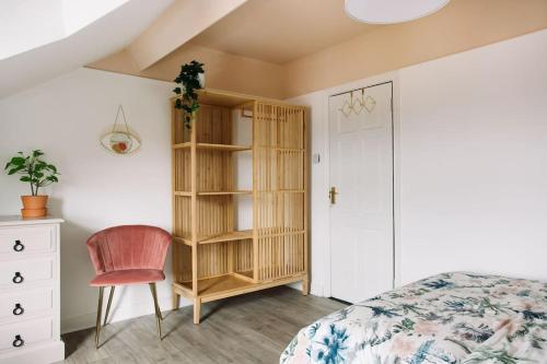 a bedroom with a bed and a chair and a book shelf at Designer 4-Bed Home in the Heart of Belfast in Belfast