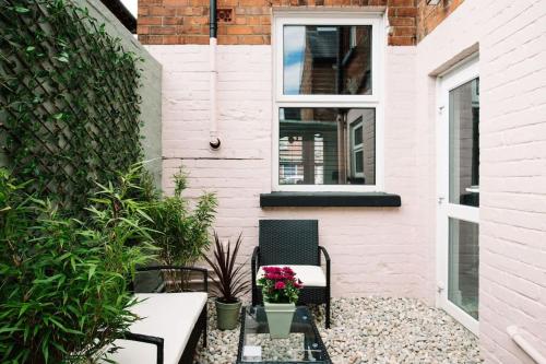 a patio with two chairs and a table with flowers at Designer 4-Bed Home in the Heart of Belfast in Belfast