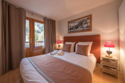 a bedroom with a large bed and a window at SavoieLac - Appartement Primeveres in La Clusaz