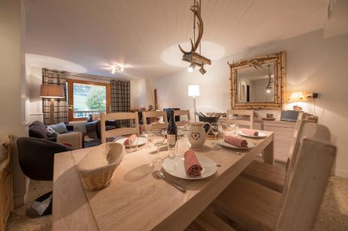 a dining room and living room with a table and chairs at SavoieLac - Appartement Primeveres in La Clusaz