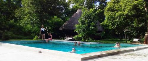 un grupo de personas en una piscina en The Nyerere Selous Ngalawa Tented Camp en Kwangwazi