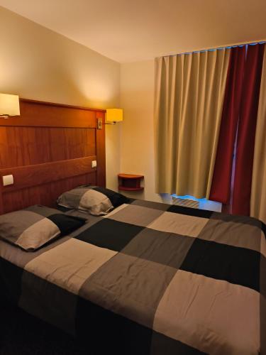 une chambre d'hôtel avec deux lits et une fenêtre dans l'établissement Résidence Le Rami Les Coches - La Plagne, à La Plagne Tarentaise