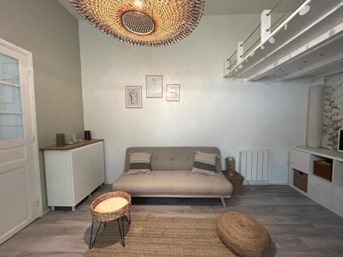 uma sala de estar com um sofá e uma mesa em Lovely studio Crimee em Paris
