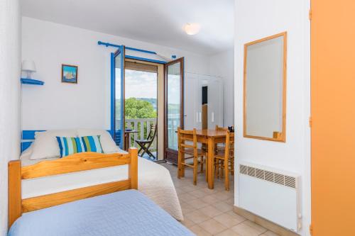 une chambre avec un lit, un bureau et une table dans l'établissement Studi-Hôtel Résidence Plein Voile, aux Salles-sur-Verdon