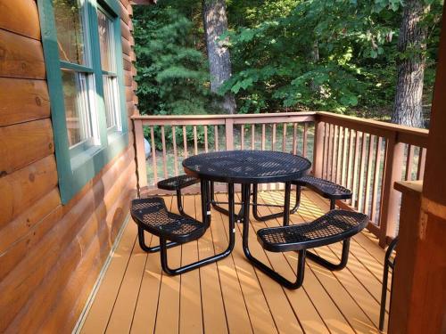 a table and four chairs on a wooden deck at Yogi's Den: Breathtaking Views! 3 min to Dollywood, on 1 acre! in Sevierville