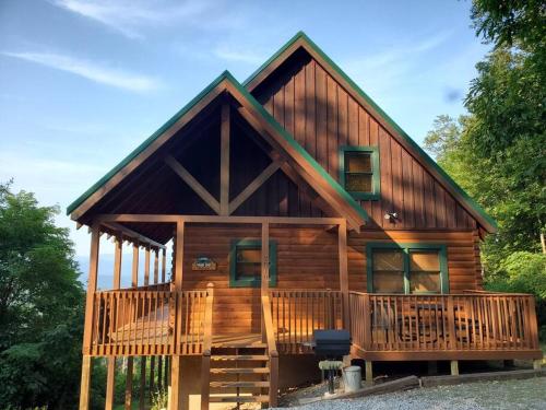 a log cabin with a wrap around deck at Yogi's Den: Breathtaking Views! 3 min to Dollywood, on 1 acre! in Sevierville