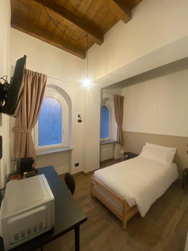 a bedroom with a bed and a desk with a tv at CENTER'S ROOMS GARLASCO City Haven in Garlasco