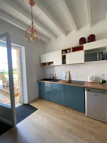 une cuisine avec des armoires bleues et un comptoir dans l'établissement Gîte au coeur du vignoble de Saint-Emilion, à Saint-Sulpice-de-Faleyrens