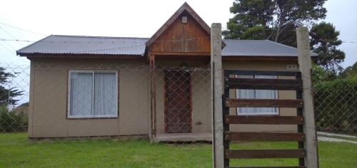 a small house behind a fence with a gate at mis perros in Mar del Plata