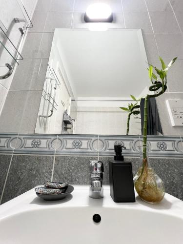 a bathroom with a sink with a vase and a mirror at 212 Apartment, A 2-bedroom escape in Paphos City
