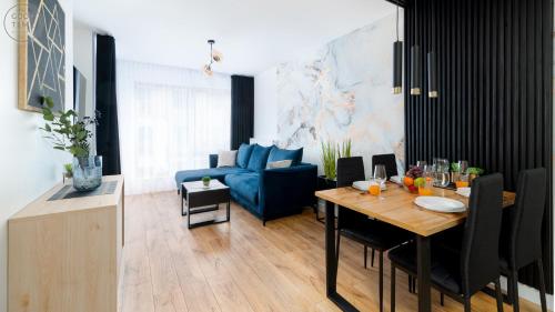 a living room with a table and a blue couch at Apartamenty Good Time- Centrum, blisko wyciągu i szlaków in Szklarska Poręba