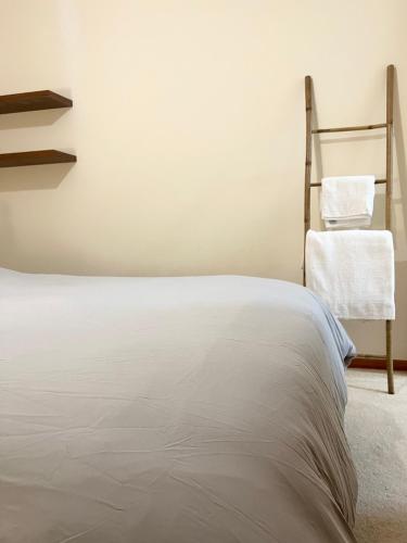 a white bed in a room with a chair at 212 Apartment, A 2-bedroom escape in Paphos City