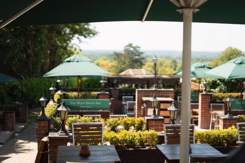 a patio with tables and chairs with umbrellas at The Black Horse Inn in Maidstone