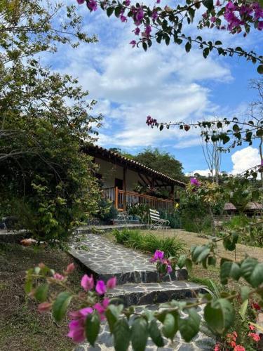 a stone path leading to a house with pink flowers at Finca Sierra Luz in Jericó