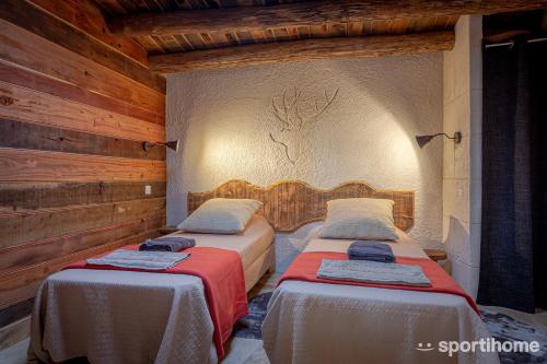 deux lits dans une chambre aux murs en bois dans l'établissement Le Cul de Loup, à Crouy-sur-Cosson