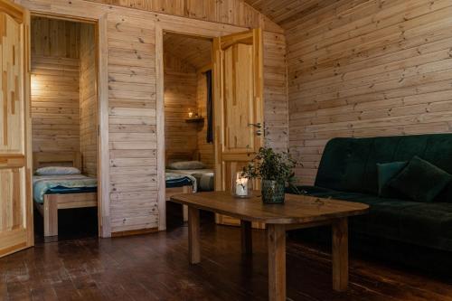 a living room with a green couch and a table at Kempings Bejas in Babīte