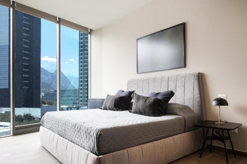 1 dormitorio con cama grande y ventana grande en Lujoso departamento a 5 minutos de San Pedro, en Monterrey