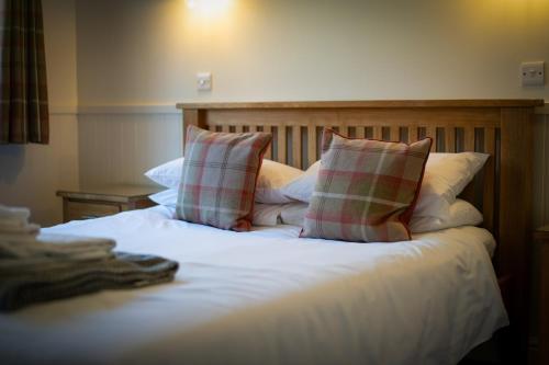 a bed with two pillows on top of it at The Black Horse Inn in Maidstone