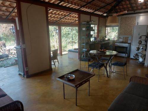 ein Wohnzimmer mit einem Tisch und einer Küche in der Unterkunft Casas e apartamentos da Praia, Lapinha na beira do lago in Santana do Riacho
