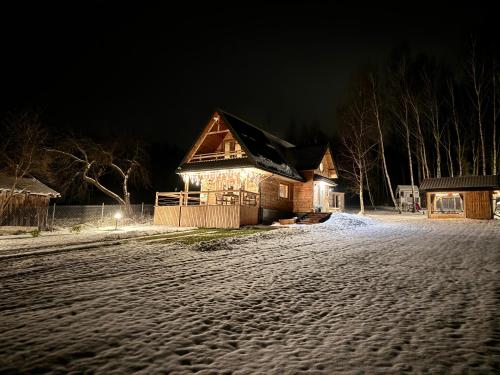 una casa en una calle nevada por la noche en GRABNIK55, en Krasnobród