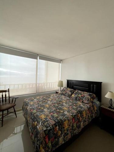 1 dormitorio con cama y ventana grande en Departamento amoblado en Reñaca, en Viña del Mar
