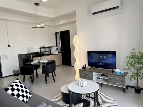 日落洞Georgetown Modern Stylish Urban 3BR, InfinityPool with Seaview, 3 Queen bed的客厅配有沙发、桌子和电视