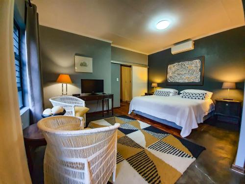 a bedroom with a bed and two chairs at The Melville Quarters in Johannesburg