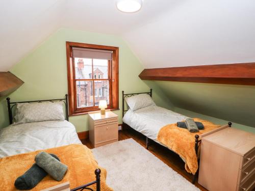 2 camas individuais num quarto com uma janela em 23 Chatsworth Square em Carlisle