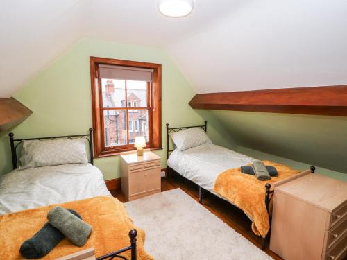 two twin beds in a room with a window at 23 Chatsworth Square in Carlisle